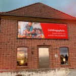 Das E-Werk in Stade mit einem Banner. Darauf ist links eine glückliche Familie in der Küche und rechts die Aufschrift „Lieblingsplatz. Unsere Küche von Gatzke Freudenberg“ und das Getzke Freudenberg-Logo zu sehen.